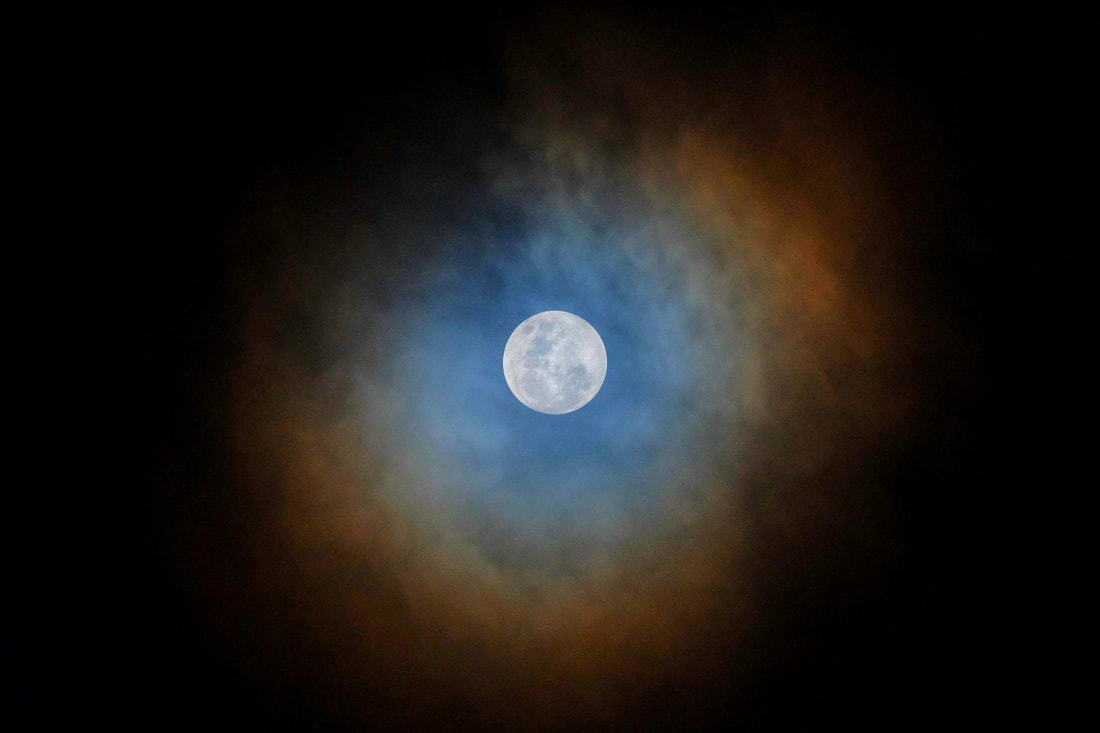 full moon with red ring in the night sky